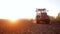 Rural work land by agriculture equipment or tractor at sunset field, nature farm