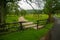 Rushing creek by a wooden fence with moss.