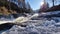 Rushing River over Rocks in Forest with Mountains