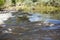 Rushing river rapids smooth flow over rocks with reflections