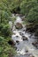 A rushing stream over rocks and boulders in a rainforest at Pua\\\'a Ka\\\'a Wayside Park, Maui