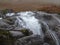 Rushing water flows over rocks called the study at Glencoe