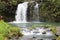 A rushing waterfall cascading over a volcanic hillside in a rainforest in Pua\\\'a Ka\\\'a Wayside Park, Haiku, Maui