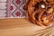 Rushnyk with korovai, wheat spikes on wooden table, flat lay. Ukrainian bread and salt welcoming tradition