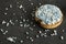 Rusk with blue aniseed balls, muisjes, tradition in the Netherlands to celebrate the birth of a son. Against dark background.