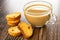 Rusks with raisin, transparent cup of coffee with milk on wooden table