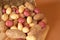 Russet, red and white potatoes spilling out of a basket onto cut