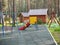 Russia, Elbrus - june 2019 playground with colored slide and wooden buildings in forest