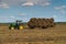 Russia. Gatchinsky district of the Leningrad region. August 28, 2021. A tractor takes away rolls of hay from the field.