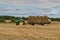 Russia. Gatchinsky district of the Leningrad region. August 28, 2021. A tractor takes away rolls of hay from the field.