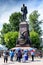 Russia, Irkutsk - July 6, 2019: tourists with umbrellas look at the monument of Alexander III. All-Russian Emperor