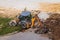 Russia, Kaluga - OCTOBER 27, 2020: Tractor breaking the old asphalt with a bucket before the construction