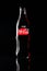 Russia Kemerovo 13-12-2018 Closeup bottle of Coca Cola on black background with beautiful flare reflected from the glass. Concept