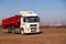 Russia Kemerovo 2019-04-09 red and white model Kamaz on field on background of city landscape and factory pipes. Concept truck on