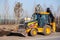 Russia Kemerovo 2019-04-11 Wheel tractor excavator loader with bucket. Concept construction works in industrial site, worksite