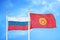 Russia and Kyrgyzstan two flags on flagpoles and blue cloudy sky