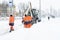 Russia Moscow 13.02.2021 Street cleaners,men clean snow from road,sidewalk with large shovels.Tractor,snow removal