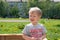 Russia, Novodvinsk, Arkhangelsk. June 2019. Summer in a small provincial town. Heat. A little blond boy of three years, squinting