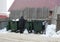 Russia, Novosibirsk, February 23, 2019: poorly dressed unemployed woman pensioner looking for garbage cans scraps and garbage