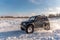Russia, Novosibirsk-January 20, 2020 Four-wheel drive SUV `Suzuki Escudo` with large wheels goes quickly raising a snowstorm on th