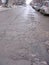 Russia, Novosibirsk, March 14, 2012: an asphalt street in a city with large holes and a ruined uneven road with parked cars