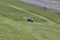 Russia, Saint-Petersburg, July 2019:lawnmower tractor works on a large area with lawn