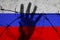 Russia sanctions. Abstract russian flag behind barbed wire fence with reaching out hand. War aggression conflict concept. Russians