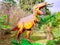 Russia, Sochi 18.02.2020. A statue of a yellow dinosaur with an open mouth on a background of palms and bare trees. Park
