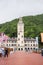 RUSSIA, SOCHI - MAY 25, 2018: Rosa Khutor resort, chapel building on a background of mountains and trees. A few tourists walk in t