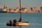 Russia, St. Petersburg, 10 June 2022: The sailing yacht with yachtsmen on board floating to port at sunset, residential