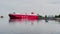 Russia, St. Petersburg, 18 June 2021: The huge ferry with trucks moves on a waterway leaving the city, red color, the