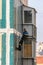 Russia, St. Petersburg, September 2020. A worker on a suspension repairs the facade of a multi-storey building.