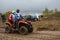 Russia, tourists on ATVs and all-terrain vehicles ride on a dirty road to the race