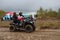 Russia, tourists on ATVs and all-terrain vehicles ride on a dirty road to the race
