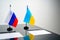 Russia and Ukraine flags on negotiation table close up