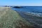 Russia. Vladivostok, coastal strip of emerald glass pebbles and a small roll of water on the shore. Glass Bay Steklyannaya, Kito