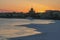 Russia, Winter St. Petersburg, a delightful winter orange golden sunset, the snow-covered Neva River. View of the Church of the As