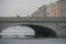 Russia, Winter St. Petersburg, Snow-covered river, soft winter daylight. Beautiful massive stone bridge close-up. Winter Russia.