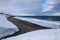 Russian Arctic View, North. Sky with clouds and blue sky reflection in water with waves and snow mountains background with stones