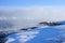 Russian Arctic View, North. Sky with clouds and blue sky reflection in water with waves and snow mountains background with stones