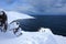 Russian Arctic View, North. Sky with clouds and blue sky reflection in water with waves and snow mountains background with stones