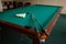 Russian billiard table with balls and cue sticks.