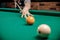 Russian billiards, man plays and beats cue on white ball