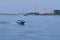 A Russian Coast Guard boat patrols a section of the Amur River. In the background, the Chinese customs building and