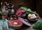 Russian cold soup with beetroot, bowls,spoons,jug,greenery on dark wooden table.