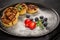 Russian cottage cheese pancakes Syrniki with berries and chocolate sauce on black ceramic  plate. Food background