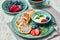 Russian cottage cheese pancakes Syrniki with berries and sour cream on light wooden background. Healthy breakfast