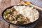 Russian cuisine: beef stroganoff with rice close-up on a plate.