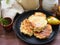 Russian cuisine : crepes pancakes on black cast iron with oak flakes on wooden background with rustic milk jug and nesting dolls