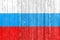 The Russian flag painted on a wooden fence. Political concept. Old texture.